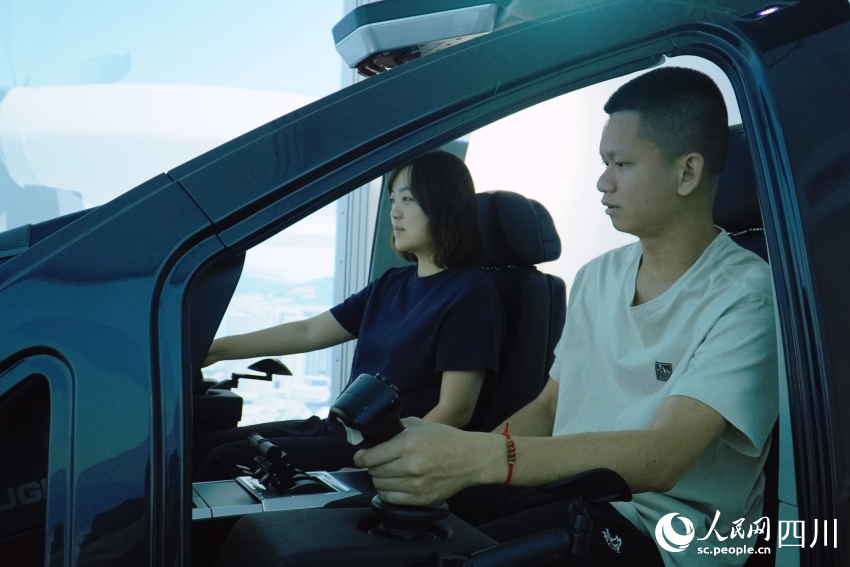 記者在AE200型“飛行汽車”模擬艙內(nèi)進(jìn)行體驗(yàn)。人民網(wǎng) 趙祖樂攝
